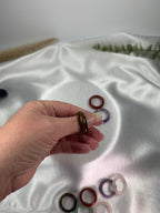 Treasured Energies crystal sphere holders spread across fingers on a white fabric background