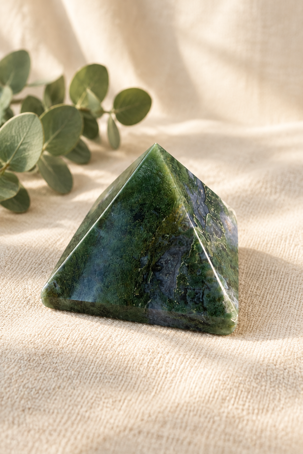 Green stone pyramid in a warm ivory linen setting