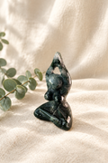 Moss agate goddess figurine in a warm linen setting
