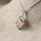 Rose Quartz Crystal Necklace Pendant Close-Up on Linen