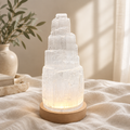 Tiered selenite crystal lamp on warm linen