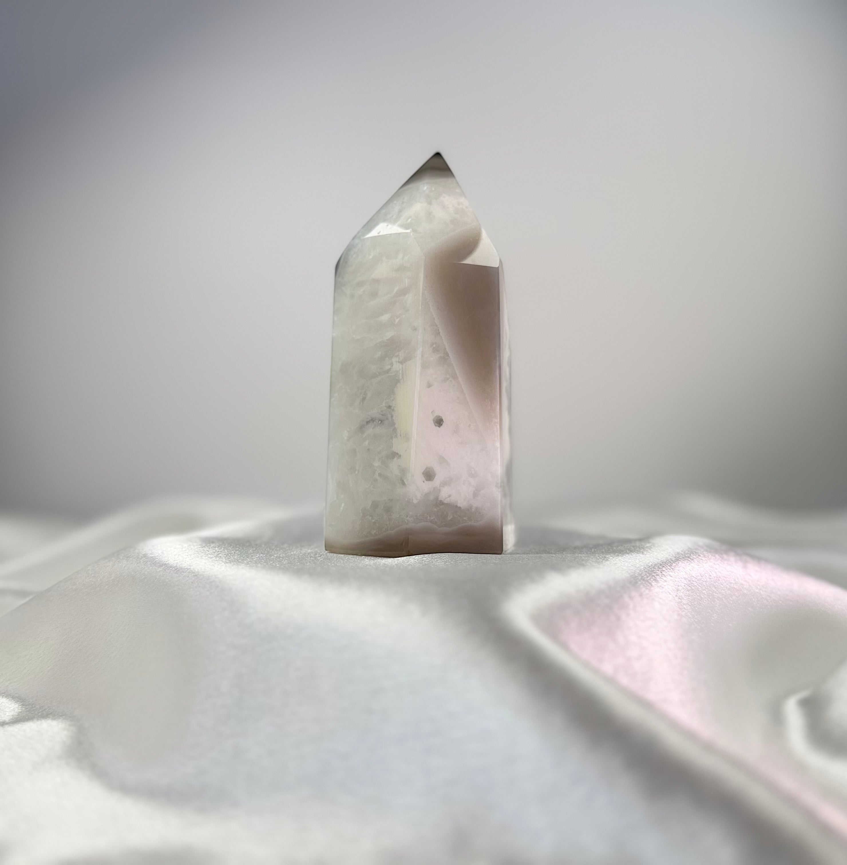 Treasured Energies polished agate crystal point with white and black tones and a sparkling druzy surface.