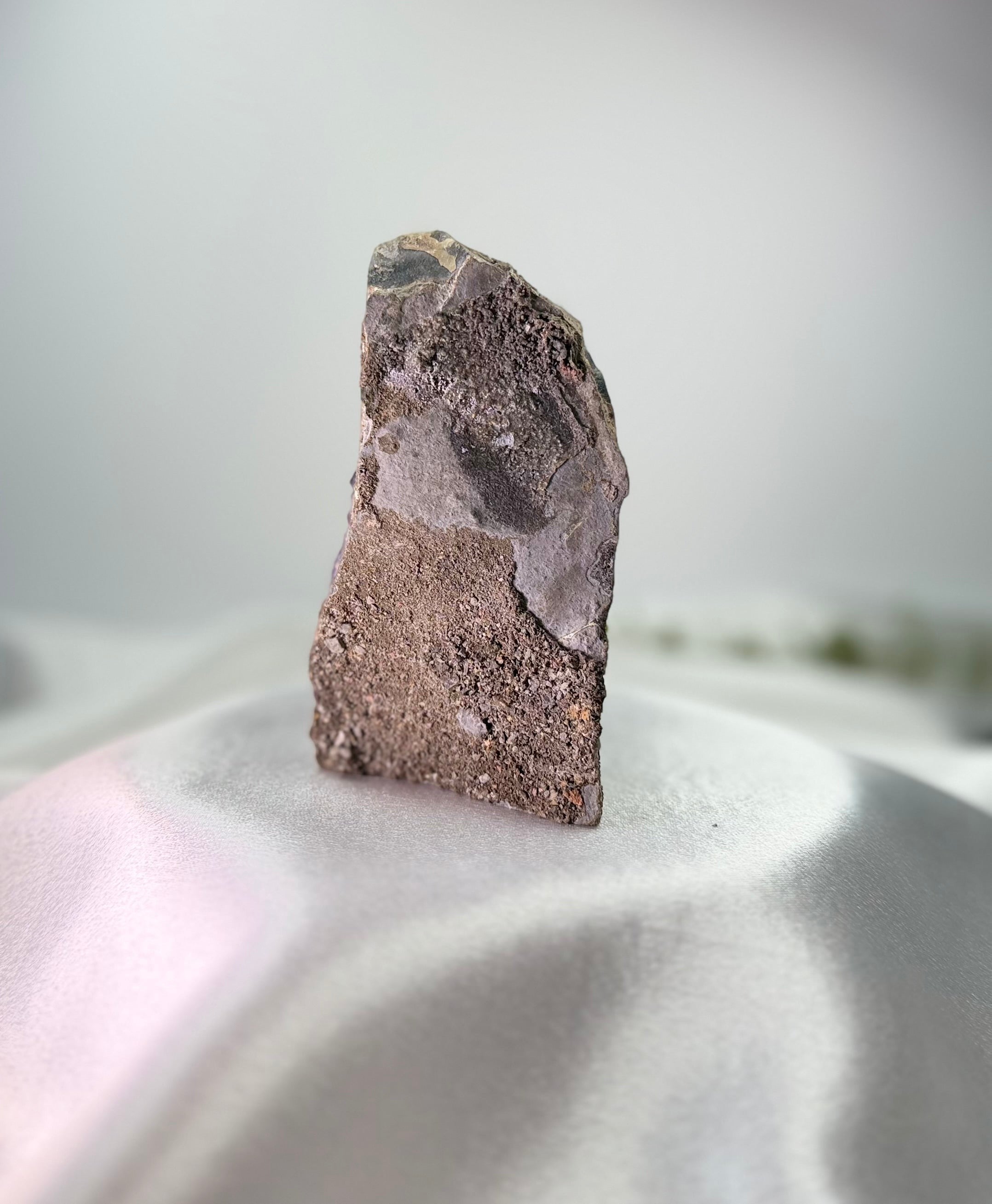 Treasured Energies freestanding amethyst cluster showing the raw, textured grey and brown stone base