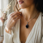 Treasured Energies amethyst crystal pendant necklace worn by a woman in a white blouse for a calming, spiritual look.