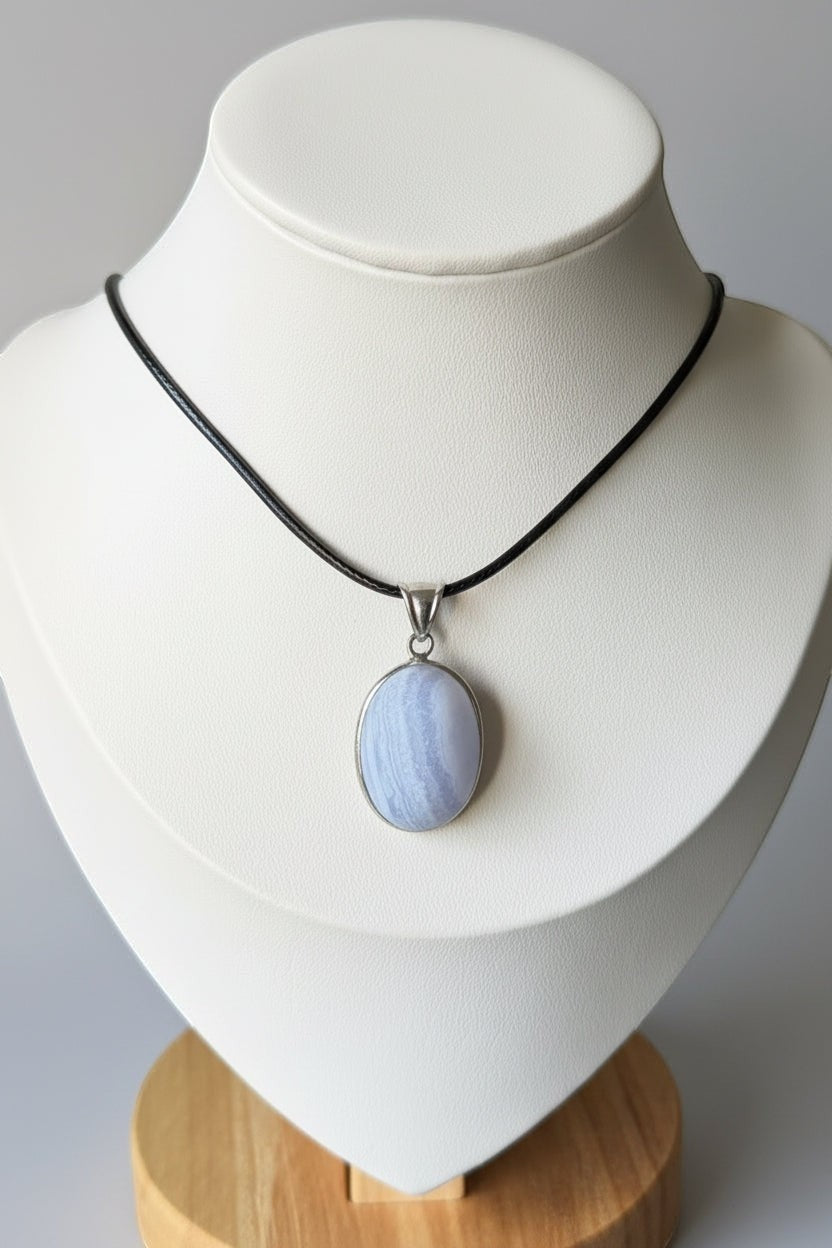 Treasured Energies blue lace agate pendant necklace with a natural matte finish on a black cord displayed on a bust.