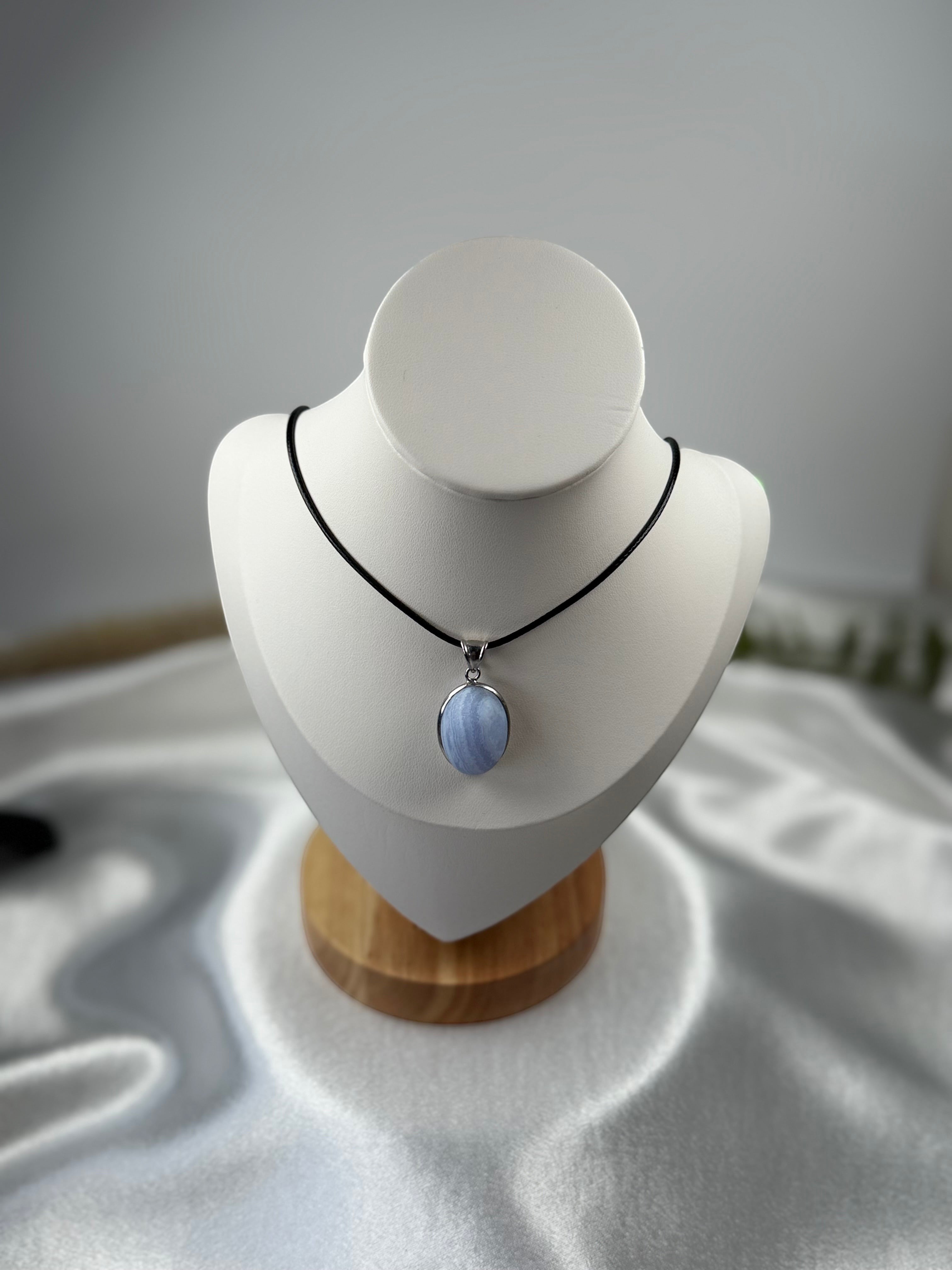 Treasured Energies blue lace agate pendant necklace with a matte finish on a black cord displayed on a mannequin bust.