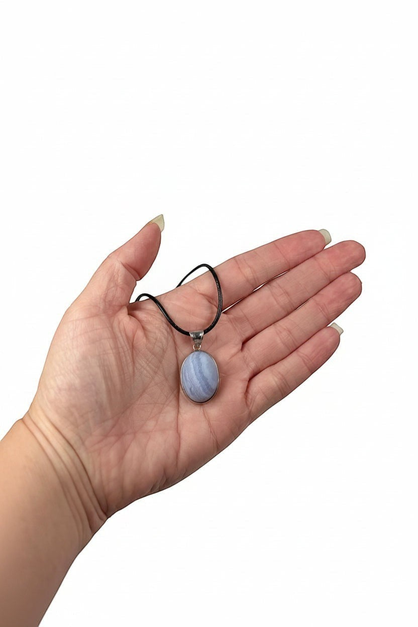 Treasured Energies blue lace agate pendant necklace with a natural matte finish held in a palm