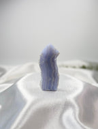 Treasured Energies Blue Lace Agate tower point with delicate light blue and white banded layers on white satin fabric.