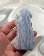 Treasured Energies Blue Lace Agate tower point with delicate blue and white banded layers held in a hand.