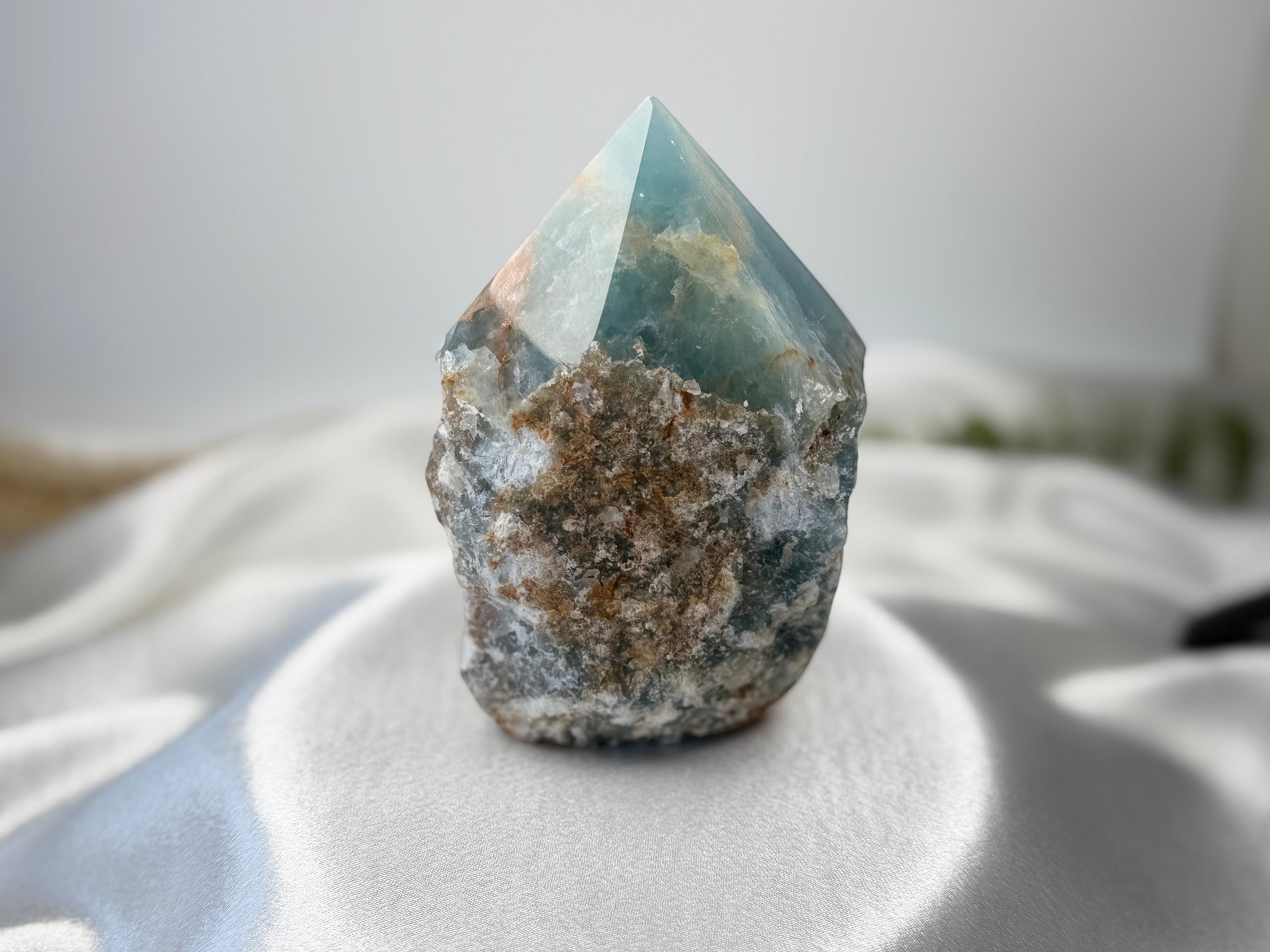 Treasured Energies Blue Onyx crystal tower with a raw, textured base and a smooth, polished pointed top.