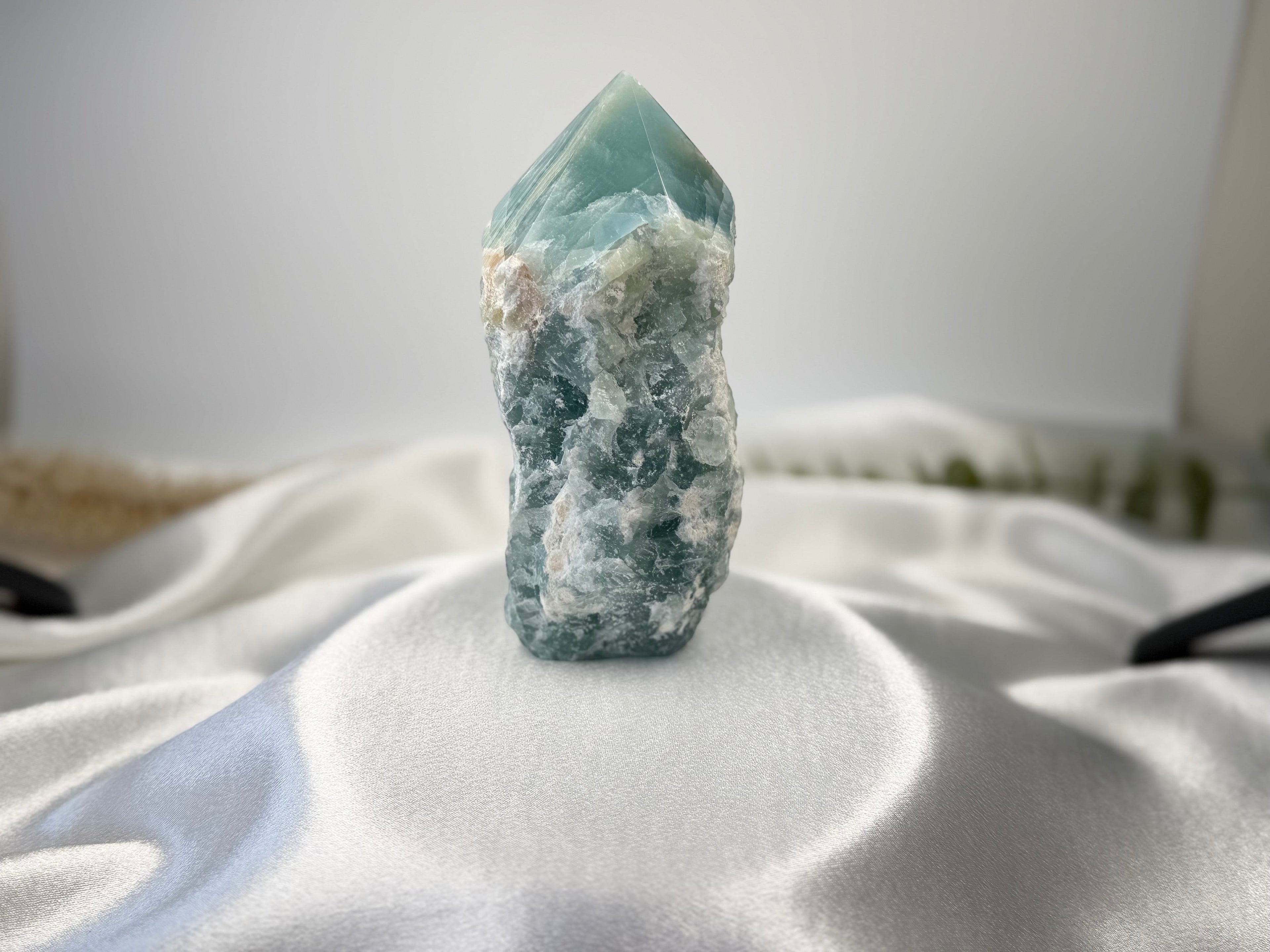 Treasured Energies Blue Onyx crystal tower with a raw, textured base and a smooth, polished faceted point.