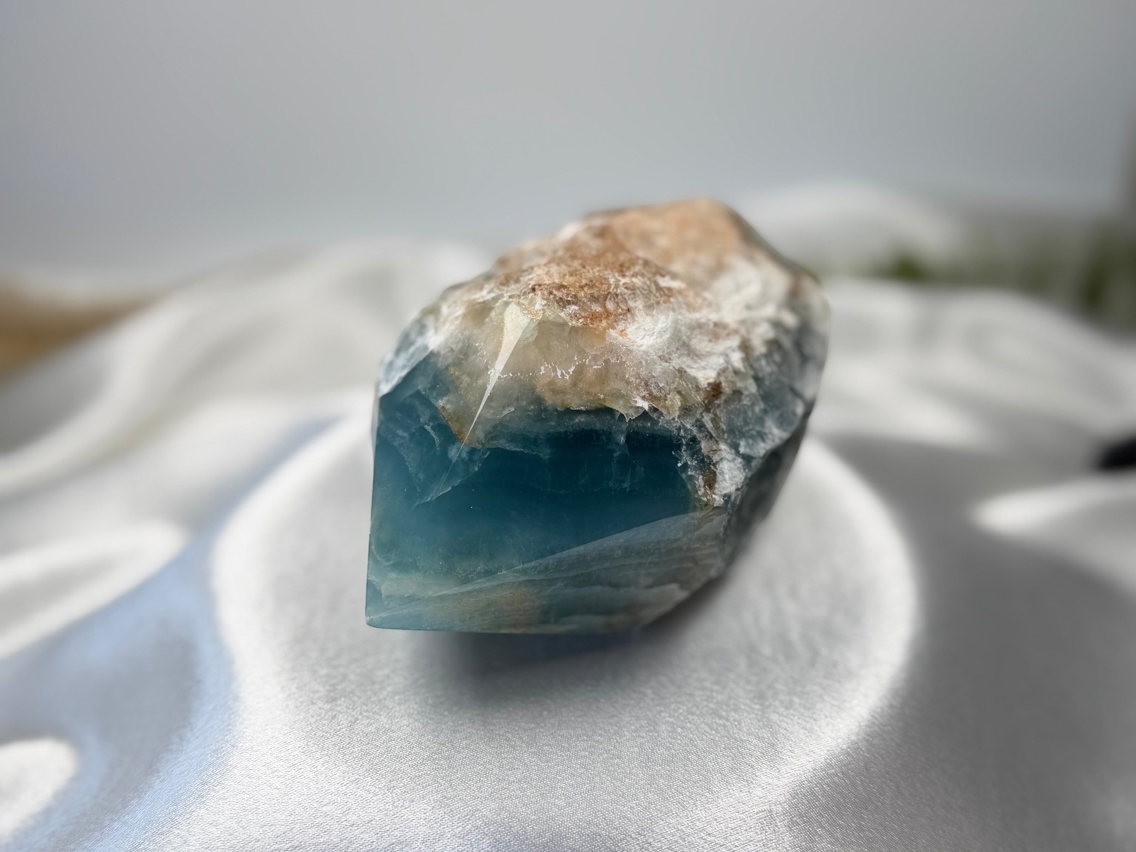 Treasured Energies blue onyx crystal with a raw, natural base and a smooth, polished tower point.