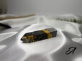 Treasured Energies Bumblebee Jasper crystal tower with vibrant yellow and black volcanic layers on white satin fabric