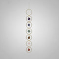 Treasured Energies 7 Chakra crystal window hanging with raw gemstones in gold circles for boho home decor.