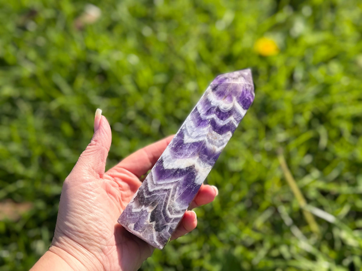 Treasured Energies Chevron Amethyst crystal tower held in hand, showing deep purple and white V-shaped bands.
