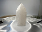 Treasured Energies clear quartz crystal tower with a raw, unpolished base and a smooth, faceted polished point.
