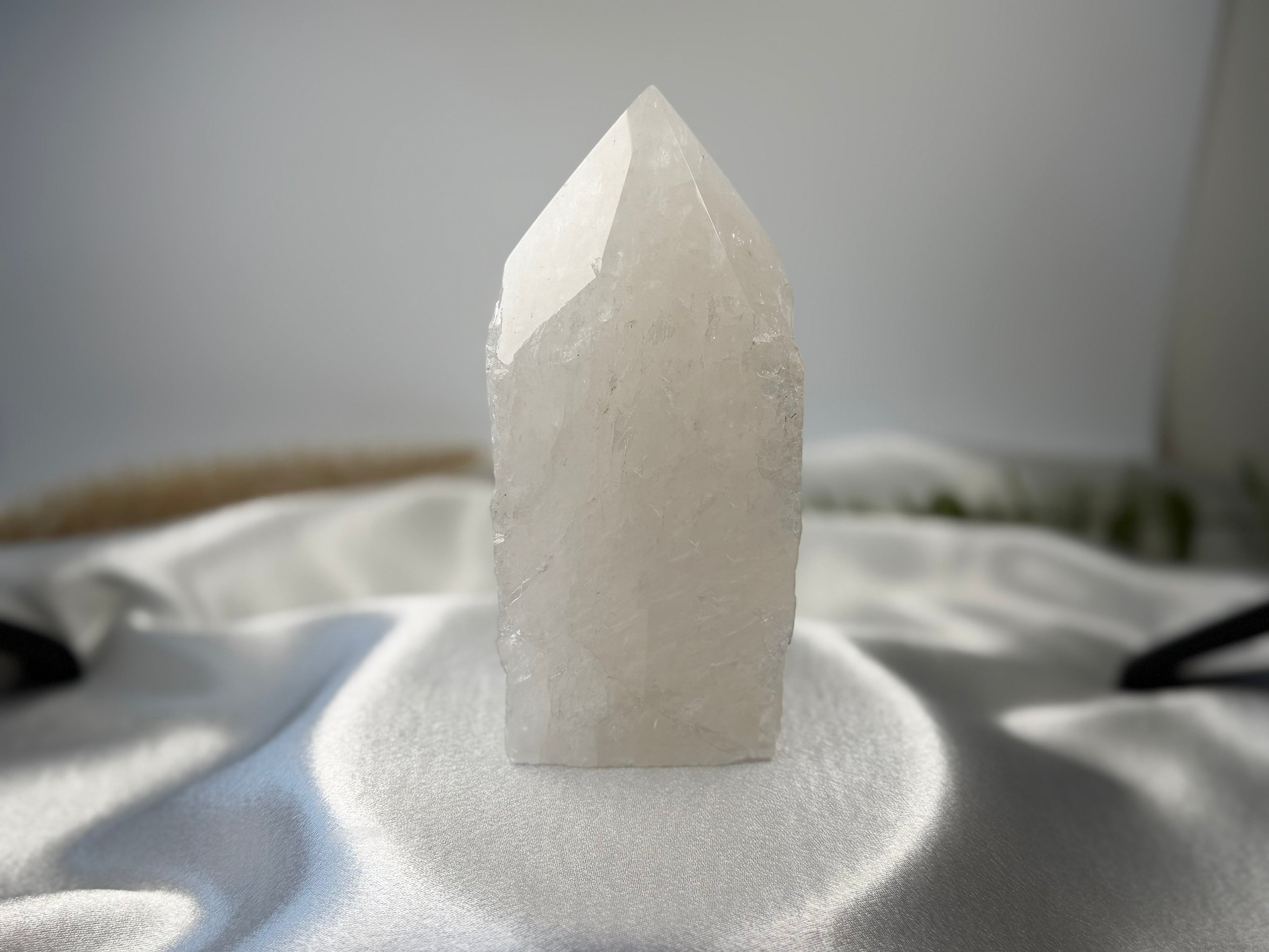 Treasured Energies clear quartz crystal tower with a raw, unpolished base and a smooth, faceted polished point.