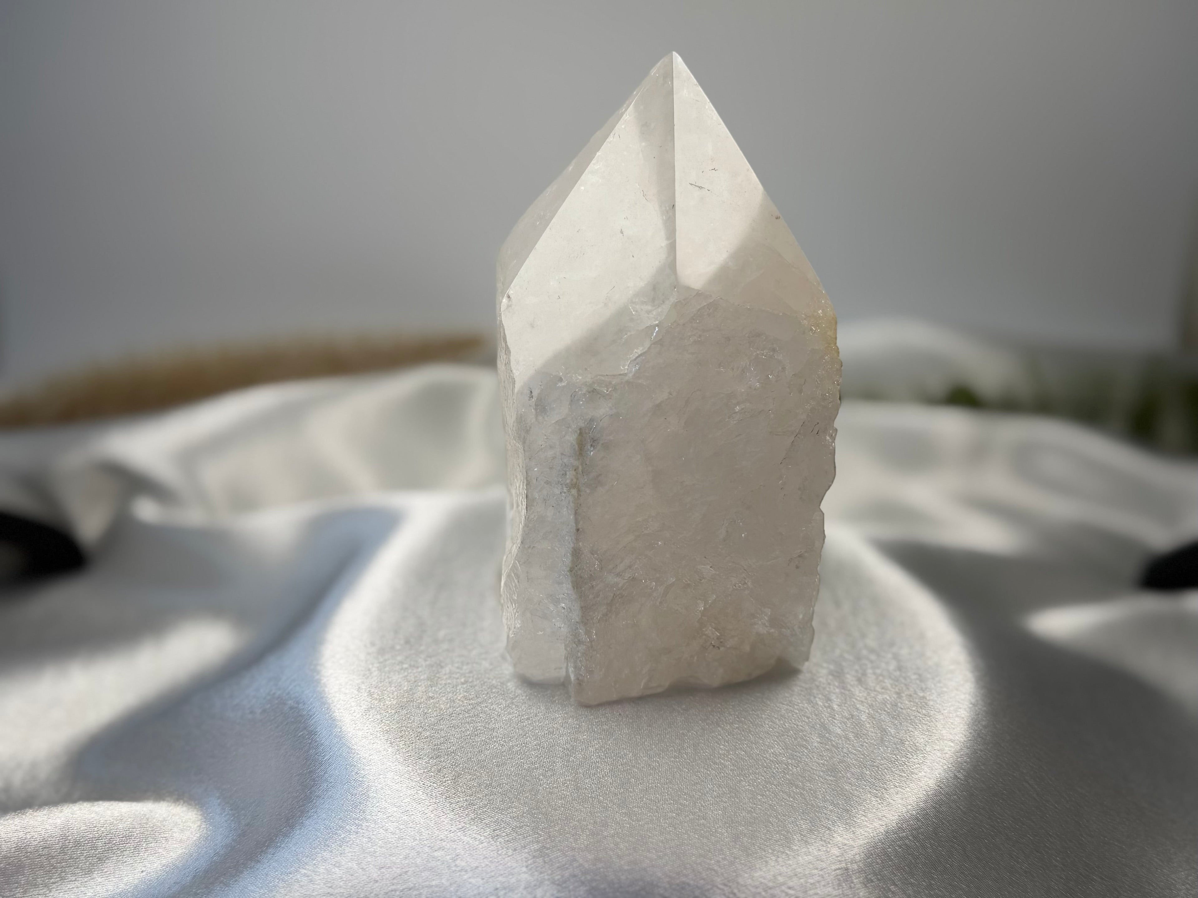 Treasured Energies clear quartz crystal tower with a raw, unpolished base and a smooth, faceted polished point.