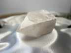 Treasured Energies clear quartz crystal tower with a raw, unpolished base and a smooth, faceted top point.
