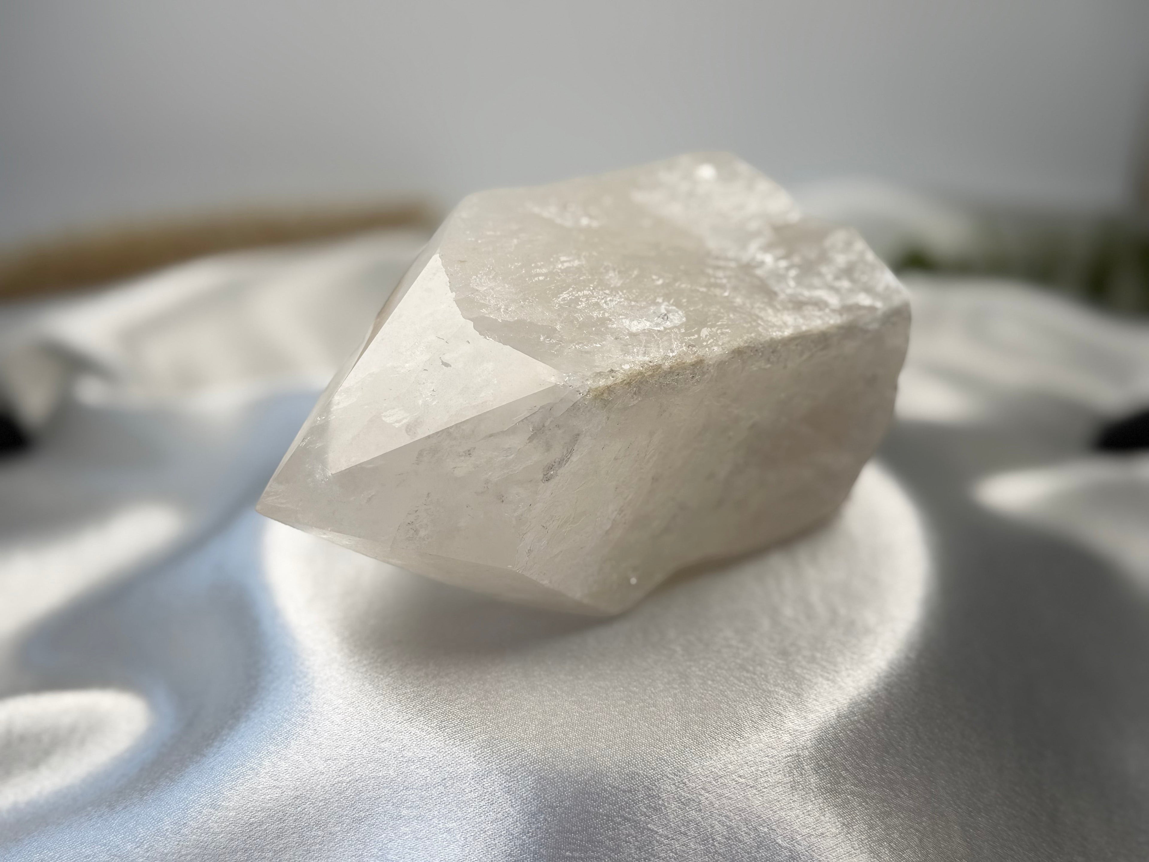 Treasured Energies clear quartz crystal tower with a raw, unpolished base and a smooth, faceted top point.