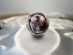 Treasured Energies polished Crazy Lace Agate crystal sphere with intricate red, white, and grey swirling patterns.