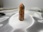 Treasured Energies Crazy Lace Agate crystal tower with intricate orange, white, and brown swirling patterns.