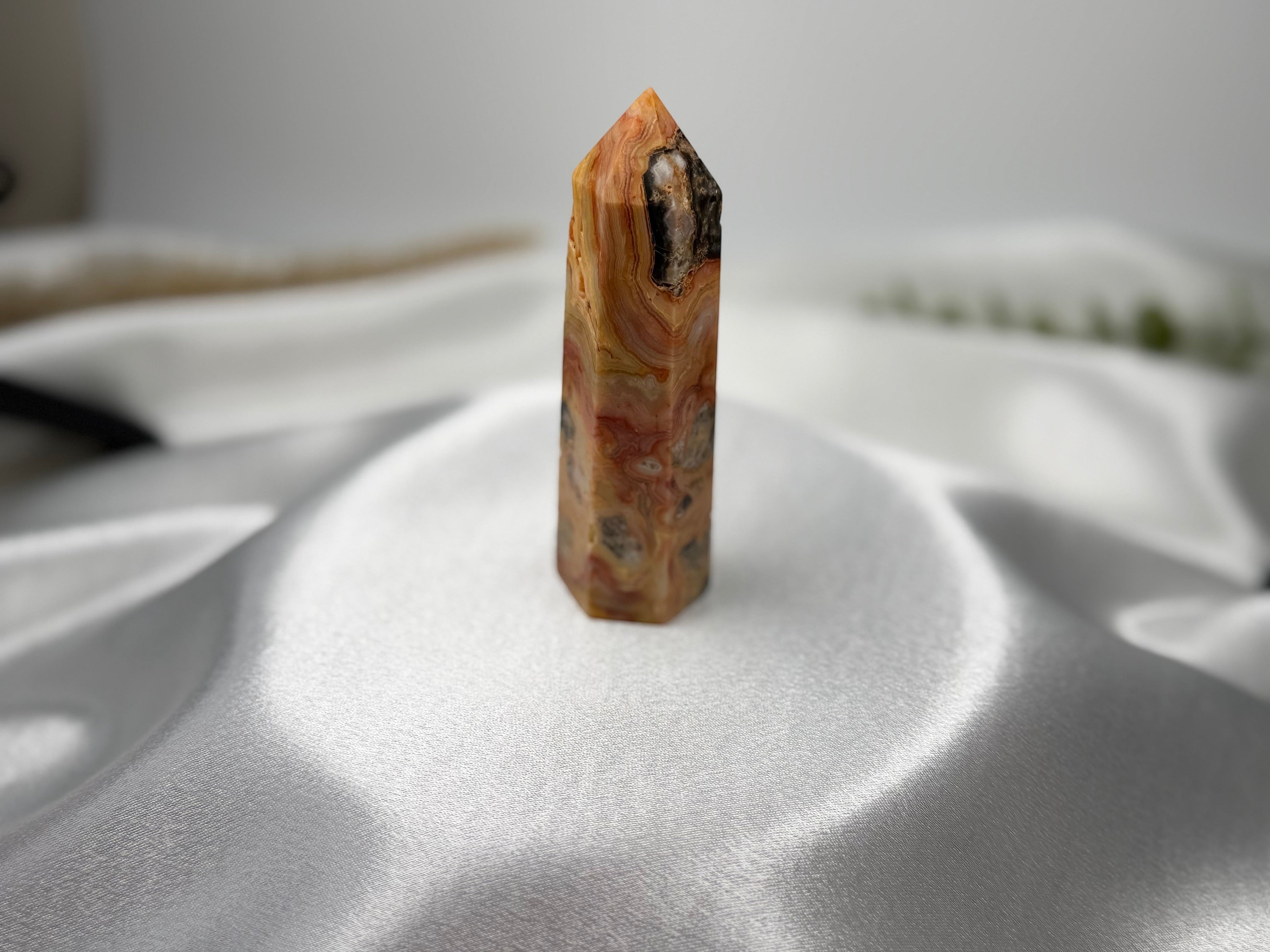 Treasured Energies Crazy Lace Agate crystal tower with intricate orange, white, and brown swirling patterns.
