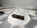 Treasured Energies Dragons Blood Jasper crystal tower with red and green patterns on a white satin background