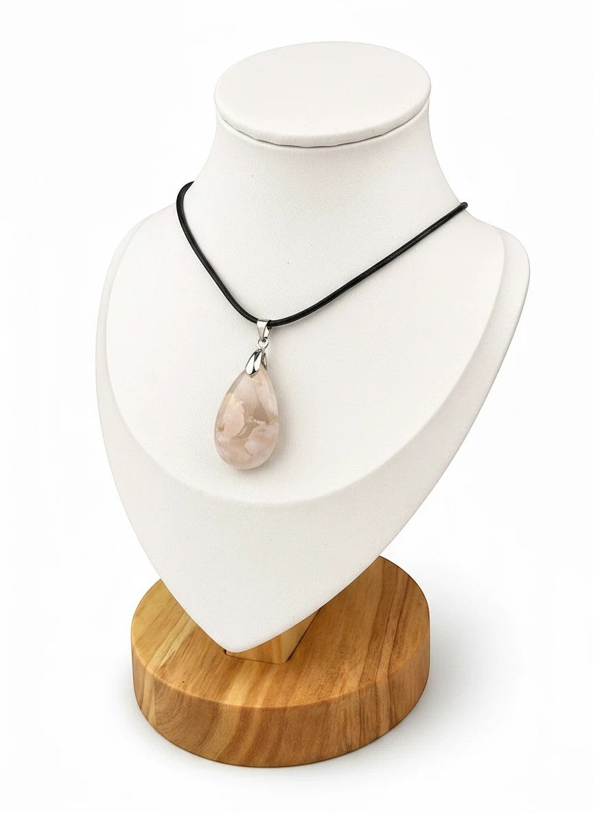 Treasured Energies teardrop flower agate pendant necklace on a black cord displayed on a white mannequin bust.
