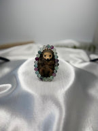 Treasured Energies fluorite crystal gemstone beaded stretch bracelet encircling a small decorative hedgehog figurine