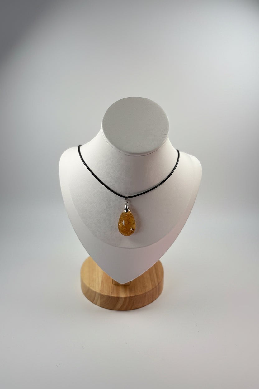 Treasured Energies golden healer quartz teardrop pendant necklace on a black cord displayed on a white mannequin bust.