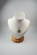 Treasured Energies green aventurine crystal pendant necklace with silver wire wrapping on a white display bust