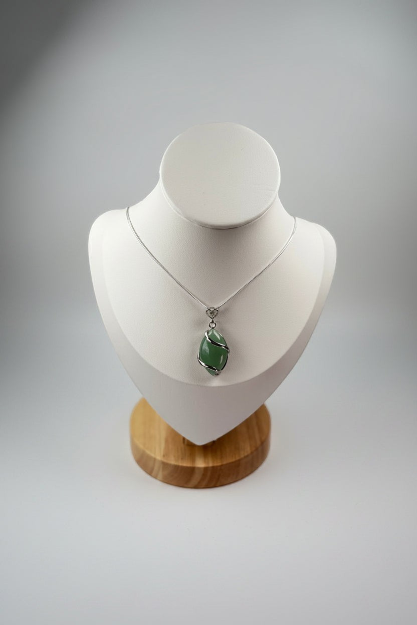 Treasured Energies green aventurine crystal pendant necklace with silver wire wrapping on a white display bust