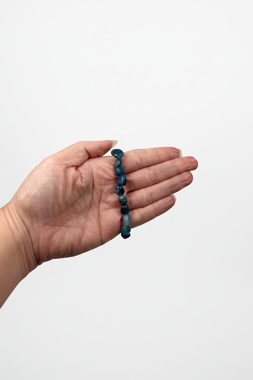 Treasured Energies polished blue kyanite gemstone bead stretch bracelet held in a palm for scale