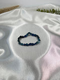 Treasured Energies polished blue kyanite gemstone bead stretch bracelet on a white satin background