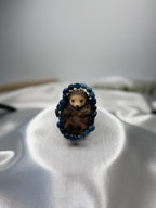 Treasured Energies polished blue kyanite gemstone bead stretch bracelet encircling a small decorative hedgehog figure