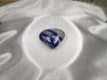 Treasured Energies polished Lapis Lazuli heart crystal with deep blue, white, and gold tones on white satin fabric.