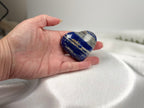 Treasured Energies medium Lapis Lazuli heart crystal held in a hand, showing deep blue stone with white calcite veins.