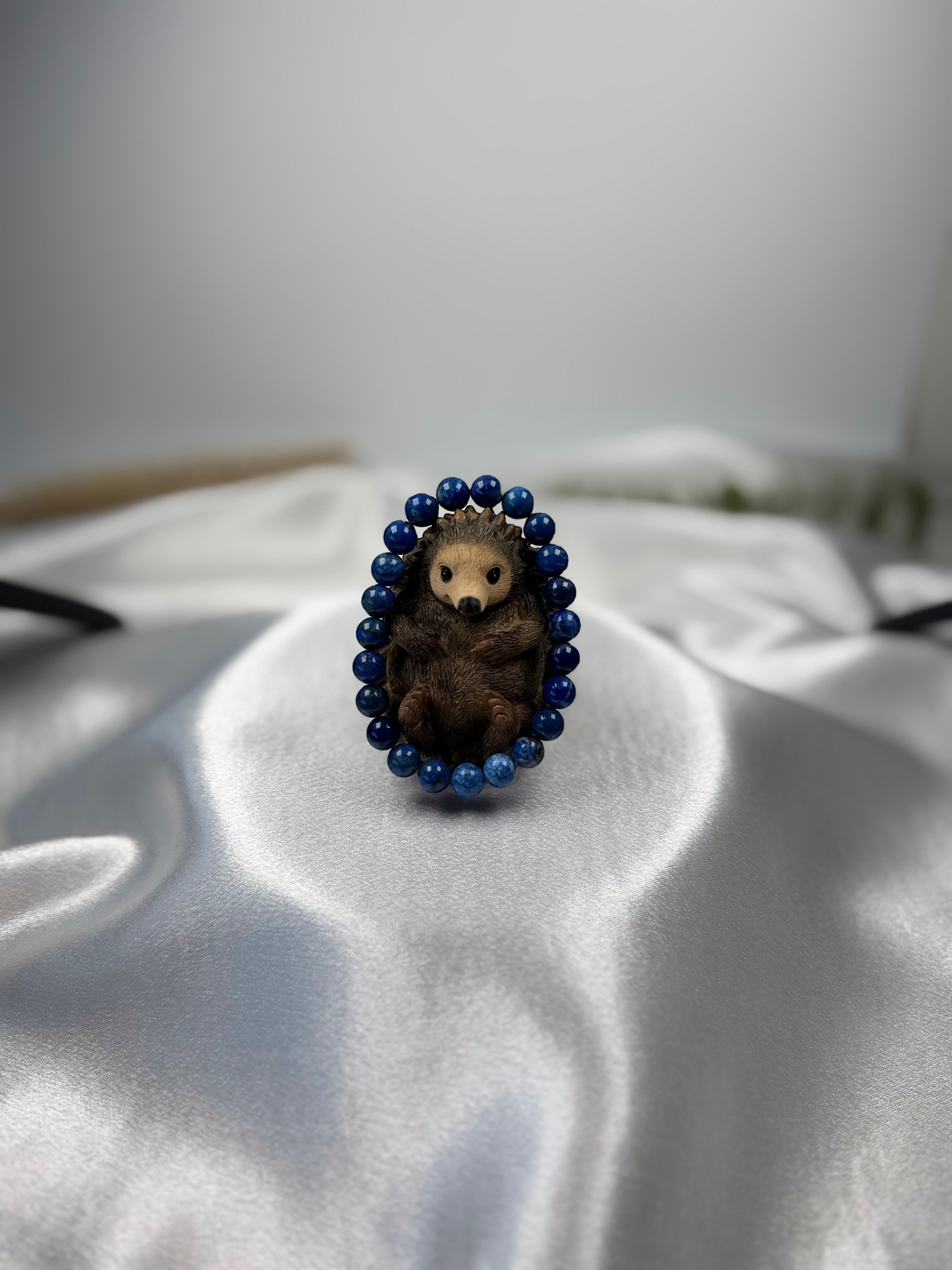 Treasured Energies Lapis Lazuli beaded elastic bracelet featuring a cute carved wooden hedgehog charm on white silk