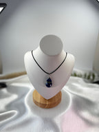 Treasured Energies teardrop Lapis Lazuli pendant necklace on a black cord displayed on a white mannequin bust.