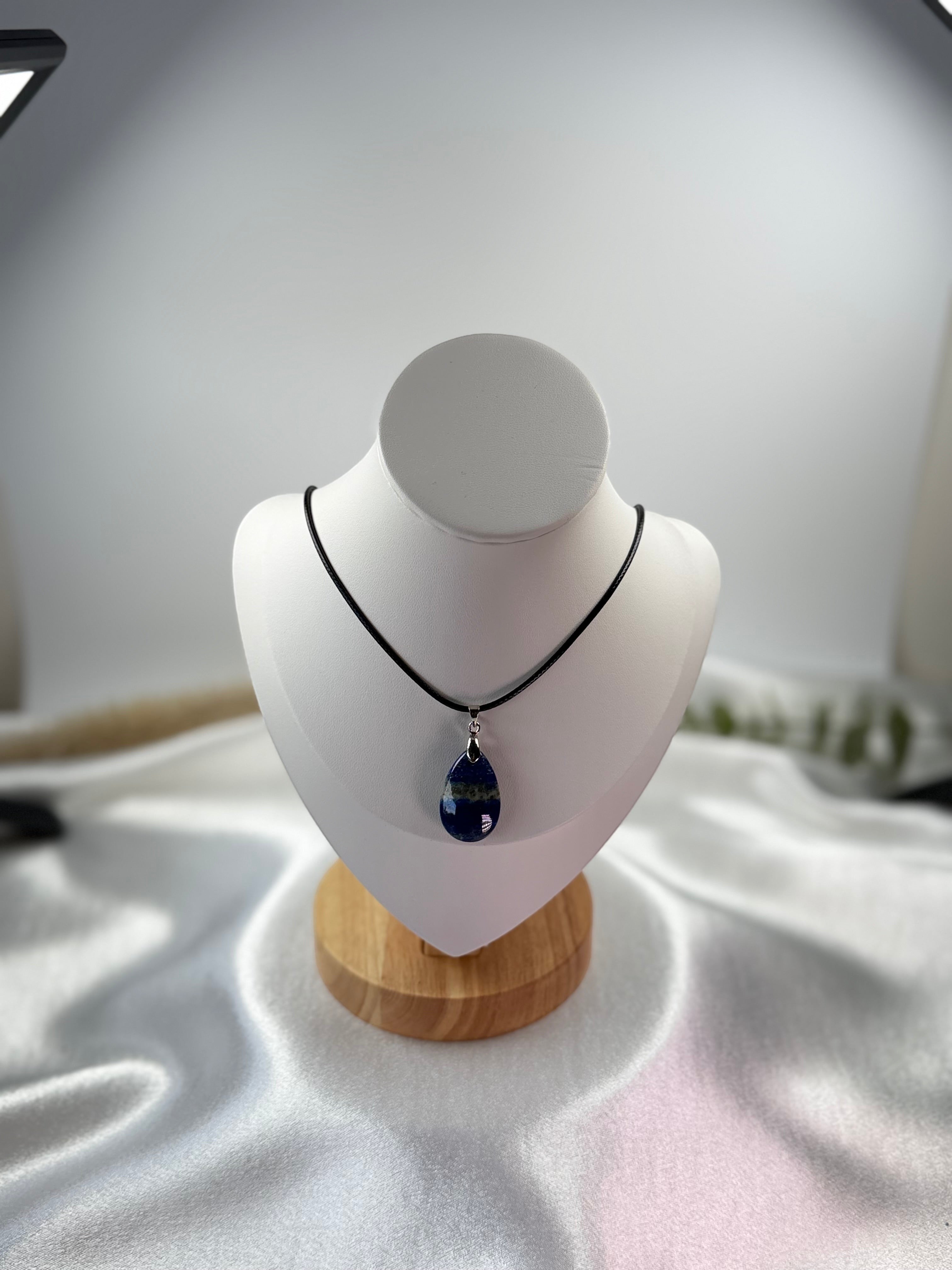 Treasured Energies teardrop Lapis Lazuli pendant necklace on a black cord displayed on a white mannequin bust.
