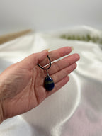 Treasured Energies teardrop Lapis Lazuli pendant necklace with golden pyrite flecks held in a hand.