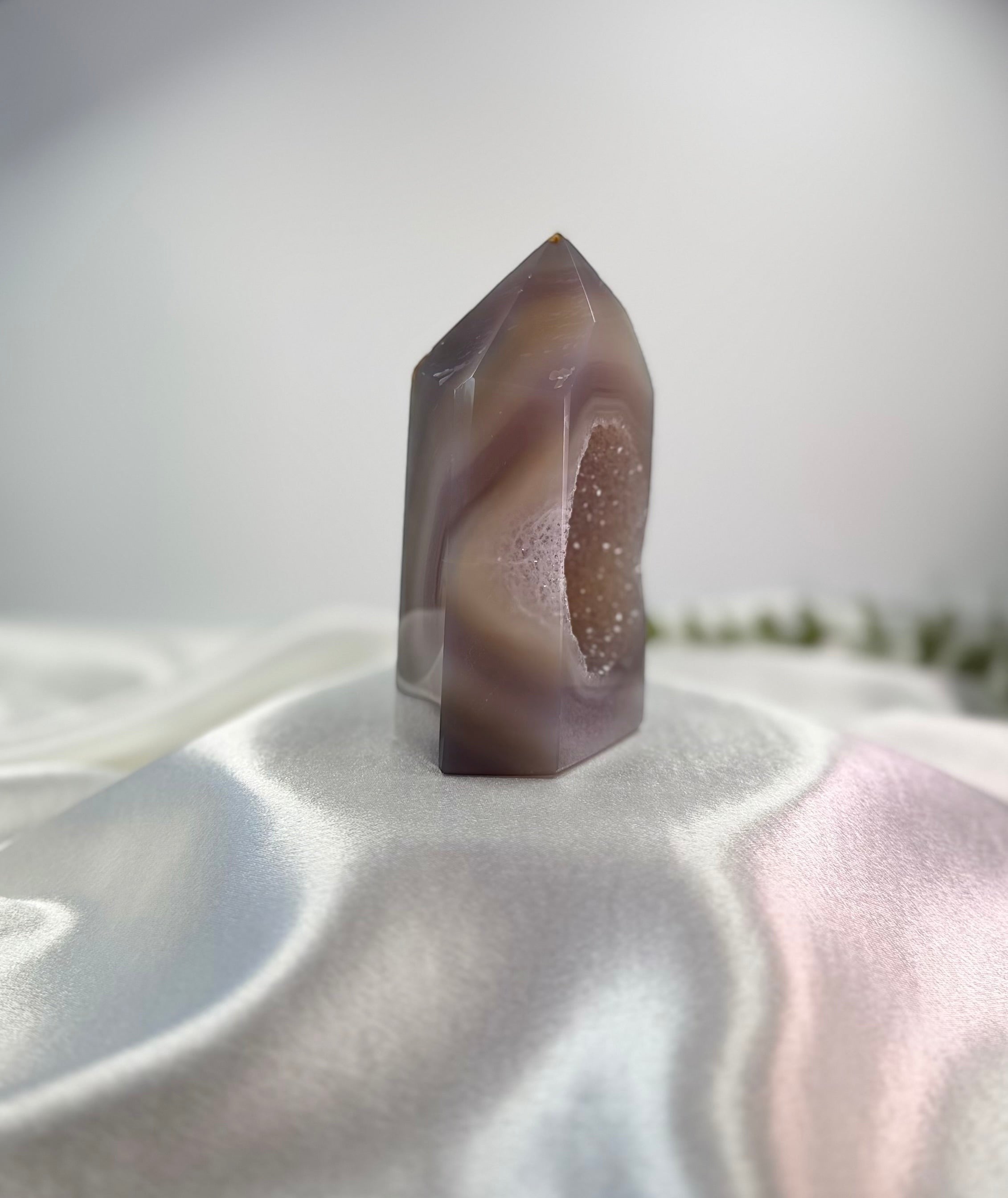 Treasured Energies polished lilac and grey agate crystal tower with a sparkling druzy geode center on white silk.