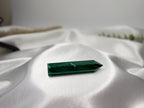 Treasured Energies polished malachite crystal generator tower with deep green banding on a white satin fabric background