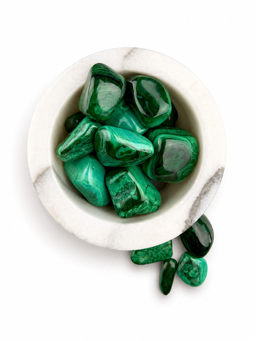 Treasured Energies high grade polished malachite tumbled stones with vibrant green banding in a white marble bowl.