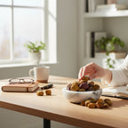 Treasured Energies Mookaite Jasper tumbled stones in a marble bowl on a wooden desk with a hand reaching for one.