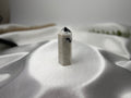 Treasured Energies moonstone crystal tower with black inclusions on a white satin background