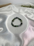 Treasured Energies moss agate crystal bead bracelet on a white satin background