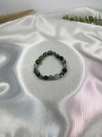 Treasured Energies moss agate crystal bead bracelet on a white satin background