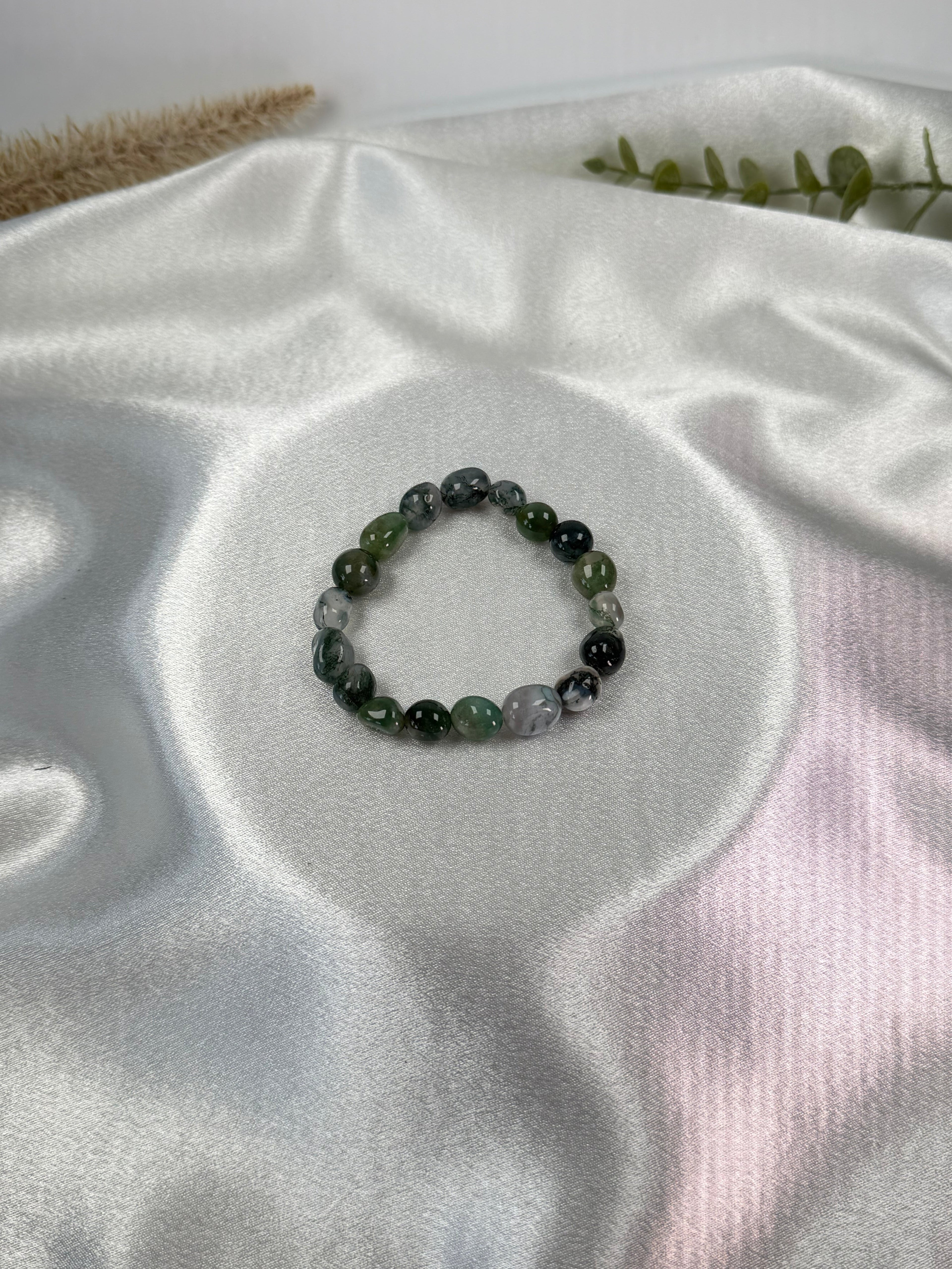Treasured Energies moss agate crystal bead bracelet on a white satin background